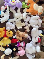 Overview of seventeen assorted plush toys on table