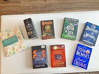 Eight hardcover books laid out on table