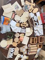 Full spread of assorted unfinished wood pieces, crates, signs, plaques and accessories on table