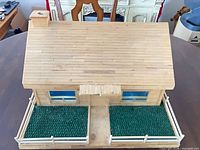 Full view of wood popsicle stick dollhouse with fenced yard