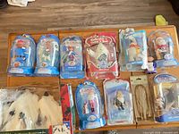 Nine blister-packed Rudolph and Santa action figures plus two other sealed items on tabletop
