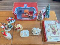 Group shot of boxed Mail Truck toy, Father Christmas, several Santa figurines, cardinal, and two ceramic cottages