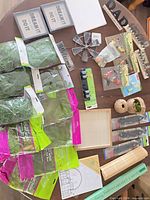 Full lot overview showing moss packs, trays, plaques, twine, hardware and additional decor items