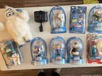 Entire lot on table: Bumble plush, camcorder with adapter, Frosty figure, seven Rudolph series figures