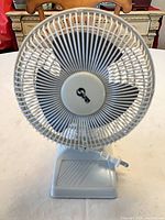 Front view of white plastic tabletop fan with power cord showing size and condition
