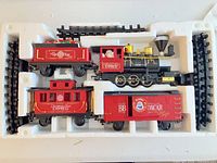 Train set in molded tray showing locomotive, three cars and track pieces