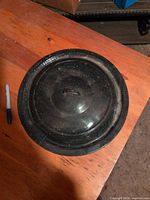 Top view of speckled enamelware lid showing handle and wear