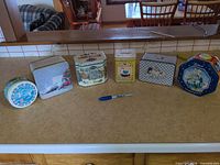 All six tins on counter for size and count reference