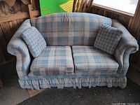 Front view of plaid loveseat with two pillows showing overall design and condition
