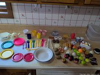 All miniature dinnerware and play food laid out on counter