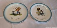 Front view of both Gigi plates showing illustrations and quotes