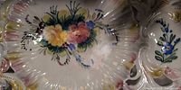 Front view of hand-painted floral plate showing scalloped reticulated rim and central bouquet