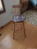 Front view of wood bar stool with octagonal plaid seat and backrest