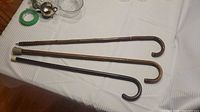 Three wood shepherd crook canes on table