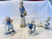 All four porcelain figurines displayed upright