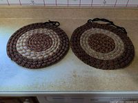 Pair of round braided seat covers on countertop