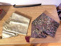 Gold and floral table runners folded on tabletop