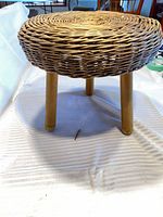Stool angled view showing wicker seat and wood legs
