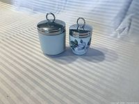 Both egg coddlers with lids on, side by side