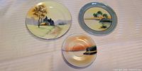 All three hand-painted landscape plates front view