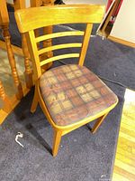 Three-quarter view of chair showing wood finish and plaid seat
