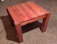 Top view of square solid wood table showing planked surface