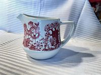 Overall view of ceramic creamer showing pattern, handle and spout