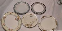 Five floral dinner plates and two platters arranged on surface