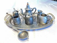 Entire eight-piece metal tea set on oval tray