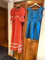 Both dresses hanging on closet doors