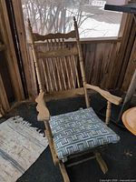 Full view of wooden rocking chair with cushion