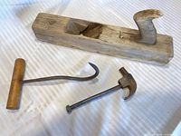 Wood bench plane, hay hook and claw hammer grouped