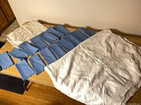 overview showing two folded tablecloths and array of blue napkins