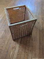 Perspective view of square wicker basket showing weave and one cutout handle