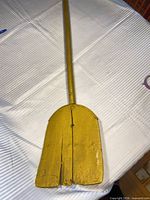 Full view of yellow wooden shovel on table