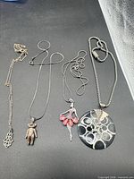 Four necklaces with distinct pendants displayed