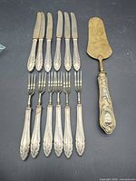 Set laid out: six knives, six forks, one server