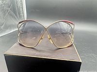 Front view of oversized gold and burgundy Christian Dior sunglasses