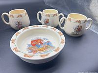 Three two-handled Bunnykins cups and one bowl displayed