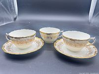 Three teacups and two saucers displayed