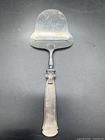 Full view of the sterling silver cheese slicer showing overall form