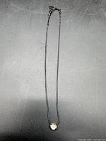 Full view of necklace laid flat showing chain and pendant