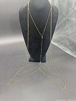 Full view of gold-tone layered body chain necklace on bust