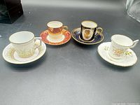 Four demitasse cup and saucer sets displayed