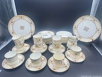 full set displayed: plates, cups, saucers, sugar bowl, creamer