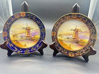 Pair of signed hand-painted cabinet plates on stands