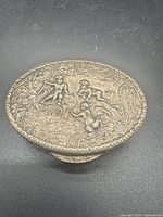 Top view showing full repousse cherub scene on lid