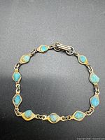 Full view of gold-tone bracelet showing all turquoise stones and clasp
