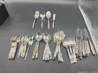 Entire assortment of flatware laid out, showing quantity and variety