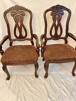 front view of both carved wooden chairs